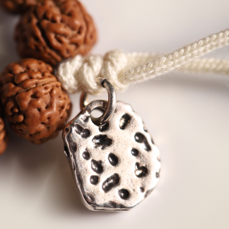 Rudraksha Strand, Natural Ridges — Selection Zero — metal tag and cord macro