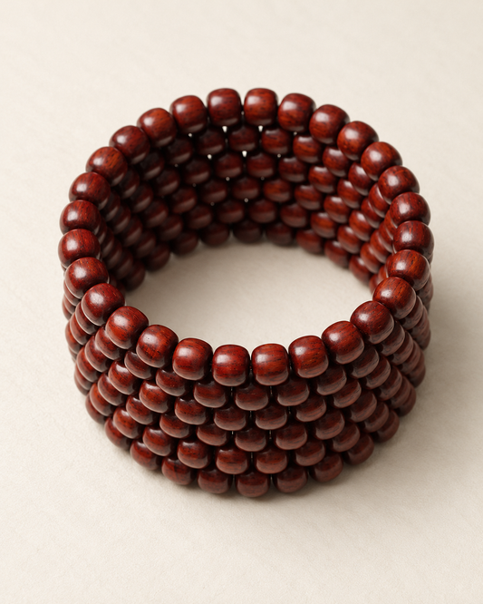 Coiled strand of 8 mm zitan beads on an ivory surface